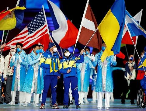 HARAPAN KEAMANAN: Atlet serta relawan mengibarkan bendera negara masing-masing di majlis penutupan Sukan Paralimpik Musim Sejak Beijing kelmarin. - Foto REUTERS
