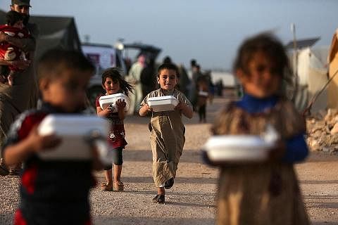 GEMBIRA DAPAT JUADAH BERBUKA: Kanak-kanak Syria yang tinggal di khemah pelarian bergembira mendapat kotak makanan yang diedarkan pertubuhan amal sebelum berbuka puasa, di sebuah khemah berdekatan sempadan Syria-Turkey. - Foto AFP MANISAN BERBUKA: Seo