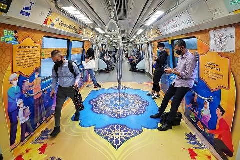 HIASAN RAYA: Kereta api MRT dihias dengan corak berwarna-warni bertema Hari Raya, dengan memaparkan ikon yang mendapat inspirasi daripada nilai dan tradisi masyarakat Muslim. - Foto BH oleh KEVIN LIM NILAI DAN TRADISI: Encik Fahmi (tiga dari kanan) b