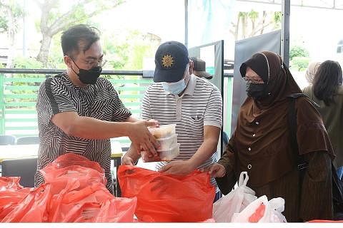 BUNGKUS KEPERLUAN DAPUR: Sukarelawan membungkus bahan-bahan asas seperti beras untuk diagihkan kepada penerima bantuan kurang berkemampuan. GOTONG-ROYONG MEMBANTU: Sukarelawan membantu membungkus dan menghantar makanan panas ke rumah penerima setiap 