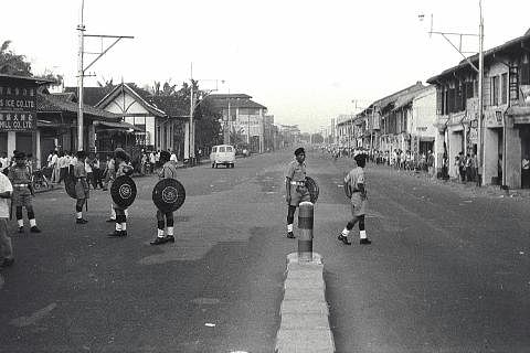 MENYINGKAP TRAGEDI BERDARAH 13 MEI 1969: Seorang askar Tentera Darat Malaysia berkawal di kawasan di mana tercetusnya rusuhan kaum di Kuala Lumpur (gambar atas). Gambar kanan pula memaparkan kejadian-kejadian membakar rumah, kedai dan harta benda ser