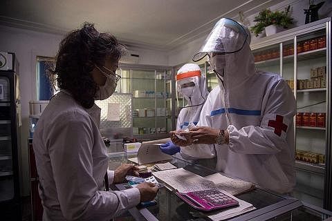 BERI UBAT: Seorang doktor (kanan) daripada Tentera Rakyat Korea melawat farmasi untuk memberi ubat kepada seorang wanita di Pyongyang, Korea Utara. - Foto AFP