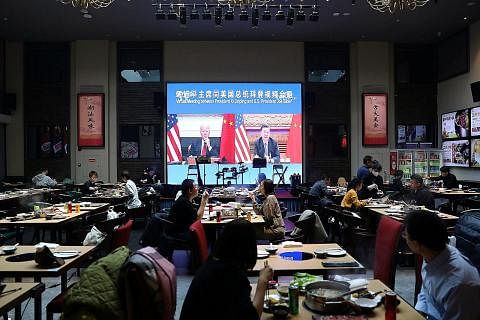 HARUS TANGANI KETEGANGAN: Orang ramai sedang menjamu selera di sebuah restoran di Beijing, China, sambil menonton pertemuan antara Presiden China, Encik Xi Jinping, dengan Presiden Amerika, Encik Joe Biden, secara dalam maya. Ketegangan Amerika-China
