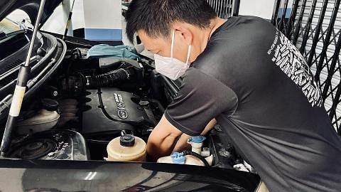 PELANGGAN MULA RAMAI: Encik Adex Chia yang sibuk membaiki salah sebuah kereta milik pemandu SIngapura mula menyaksikan peningkatan perniagaan.