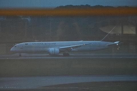 MENDARAT: Pesawat syarikat penerbangan Arab Saudi, Saudia, yang dikatakan membawa Encik Gotabaya Rajapaksa (gambar sisipan) mendarat di Lapangan Terbang Changi semalam. - Foto-foto BH oleh ARIFFIN JAMAR, AFP
