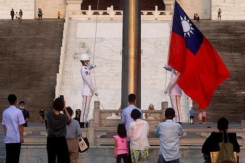 JADI PERHATIAN: Orang ramai berhimpun untuk menyaksikan para pengawal kehormatan menurunkan bendera Taiwan sewaktu matahari terbenam di Medan Kebebasan di Taipei, Khamis lalu. - Foto REUTERS