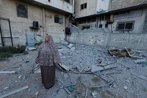 BUKTI KEMUSNAHAN: Seorang wanita Palestin melihat keadaan sebuah bangunan yang rosak teruk di mana pegawai kanan pemerintah pasukan Jihad Islam, Encik Tayseer al-Jaabari, terbunuh dalam serangan Israel ke atas Kota Gaza, semalam. - Foto REUTERS