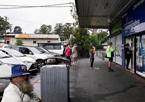 UJI DIRI: Pelanggan beratur di luar sebuah farmasi di Sydney Barat untuk membeli kit Ujian Pantas Rapid (ART) Covid-19 di Australia. - Foto REUTERS