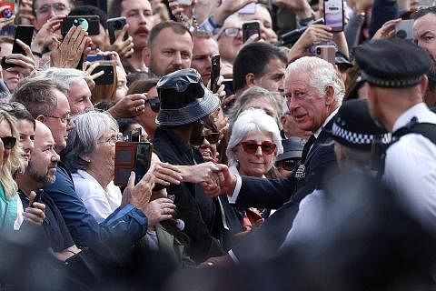 TEMU RAKYAT: Raja Charles III menerima sorakan ketika bersalaman dengan orang ramai di luar Istana Buckingham sekembali baginda dari Scotland, di mana Ratu Elizabeth II meninggal dunia pada usia 96 tahun. - Foto REUTERS PERINGATI MENDIANG RATU: Jamba