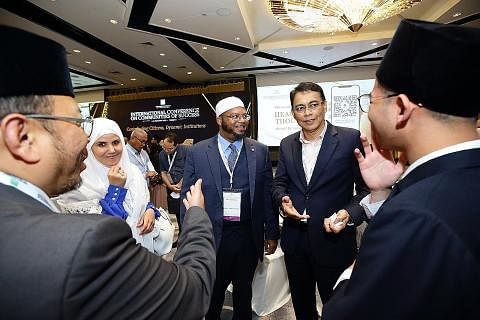 KUKUHKAN MASYARAKAT: Encik Kadir berinteraksi dengan peserta yang hadir di ICCOS di Pusat Konvensyen Raffles City baru-baru ini. - Foto MUIS