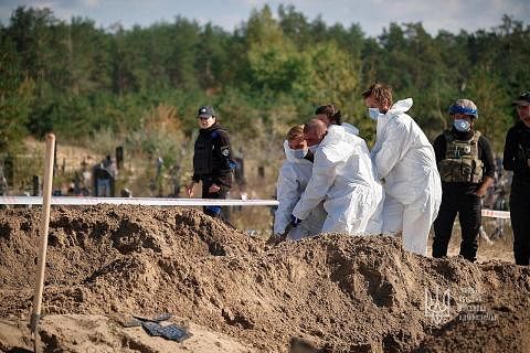 SELONGKAR KUBUR: Pegawai forensik menyelongkar kubur besar yang ditemui di bandar Lyman, yang ditawan semula oleh Ukraine baru-baru ini. Tentera Ukraine sebelum ini telah memasuki bandar Lyman di timur wilayah Donestsk, salah satu daripada empat wila