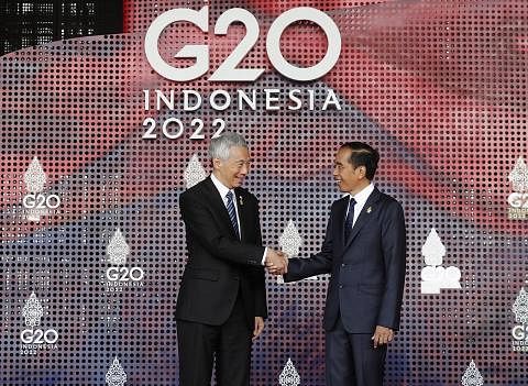 DISAMBUT MESRA: Encik Lee (kiri) disambut oleh Presiden Jokowi pagi semalam sebelum Sidang Puncak G20 dibuka secara rasmi. - Foto EPA-EFE