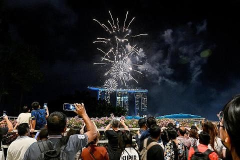 ACARA ISTIMEWA: Orang ramai berkumpul di Marina Bay untuk menikmati pertunjukan bunga api yang diadakan sempena sambutan Tahun Baru. - Foto REUTERS SESAK: Jambatan dan ruang umum di sekitar Marina Bay dibanjiri warga yang berhimpun untuk menyambut ke