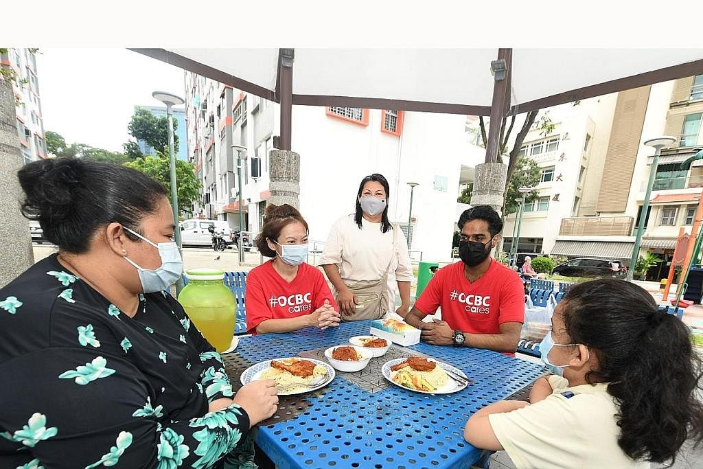 KONGSI KEGEMBIRAAN: Cik Linda dan anak perempuannya, yang menerima hidangan sempena hari ketujuh Tahun Baru Cina, berbual bersama Cik Tuty, yang merupakan tukang masak, dan relawan kakitangan OCBC. - Foto OCBC BANK