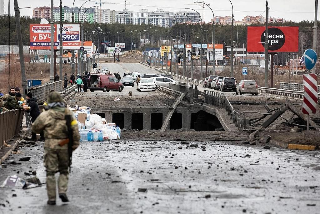 SELAMATKAN DIRI WALAUPUN SUKAR: Penduduk Ukraine yang terjejas cuba melarikan diri daripada konflik Ukraine-Russia kelmarin. Namun perjalanan mereka disukarkan apabila infrastruktur awam, termasuk jambatan, contohnya di bandar Irpin di daerah Kyiv in