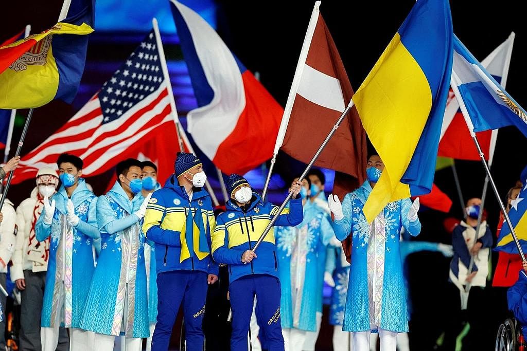 HARAPAN KEAMANAN: Atlet serta relawan mengibarkan bendera negara masing-masing di majlis penutupan Sukan Paralimpik Musim Sejak Beijing kelmarin. - Foto REUTERS