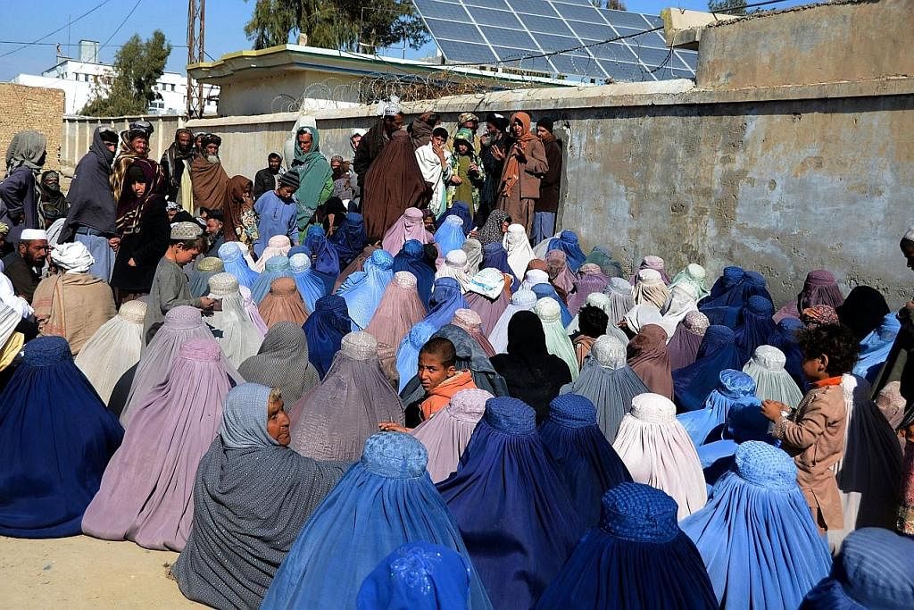 BANTUAN KEMANUSIAAN: Sekumpulan warga Afghanistan menunggu di luar pejabat Suruhanjaya Tinggi Pertubuhan Bangsa-bangsa Bersatu bagi Pelarian (UNHCR) untuk mendapatkan barangan keperluan di bandar Kandahar. - Foto REUTERS KAWAL JALAN RAYA: Beberapa mi