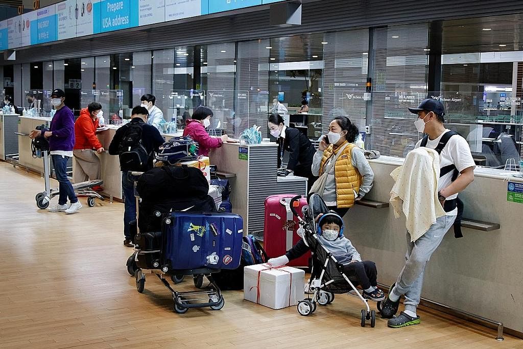 MASIH BERPELITUP: Orang ramai dilihat menjaga kesihatan diri daripada dijangkiti koronavirus semasa melakukan pemeriksaan pasport bagi kemasukan ke dewan keberangkatan di Lapangan Terbang Antarabangsa Incheon di Incheon, Korea Selatan, semasa gambar 