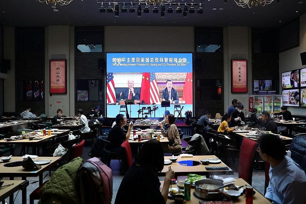 HARUS TANGANI KETEGANGAN: Orang ramai sedang menjamu selera di sebuah restoran di Beijing, China, sambil menonton pertemuan antara Presiden China, Encik Xi Jinping, dengan Presiden Amerika, Encik Joe Biden, secara dalam maya. Ketegangan Amerika-China
