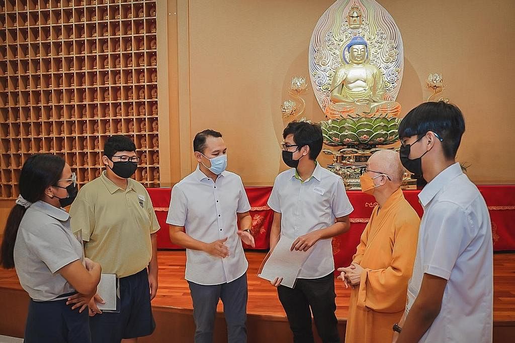 BANTU PELAJAR KELUARGA SUSAH: Encik Fahmi (tiga dari kiri) dan Presiden Persekutuan Agama Buddha Singapura, Venerable Seck Kwang Phing (dua dari kanan), memberi dorongan kepada penerima dermasiswa tahun ini. - Foto BH oleh NUR DIYANA TAHA