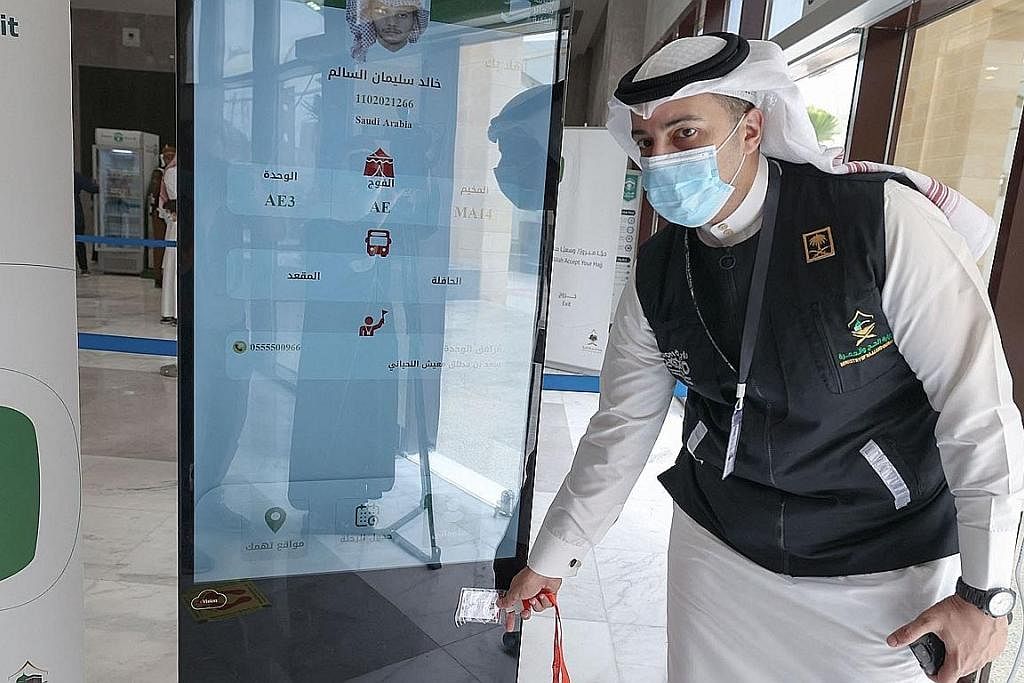 PERMUDAH PROSES: Seorang anggota Saudi mengimbas kad haji seorang anggota jemaah yang membolehkan akses tanpa sentuhan ke tapak suci, tempat penginapan dan pengangkutan. - Foto-foto AFP KAD BIJAK: Setiap kad mengandungi maklumat asas mengenai setiap 
