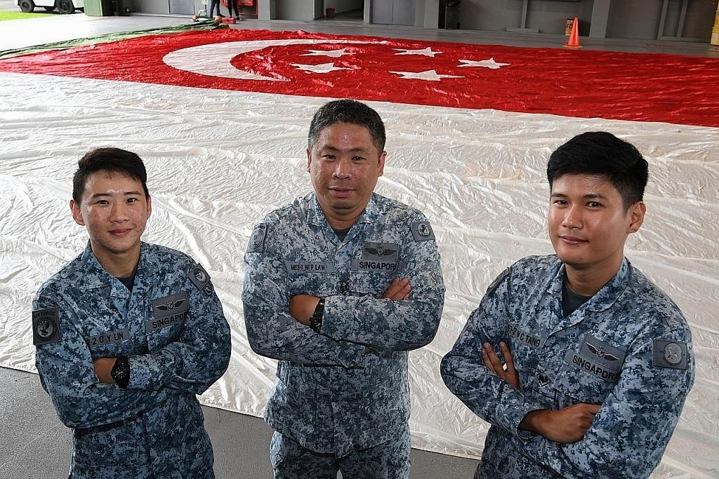 AHLI PASUKAN BENDERA: (Dari kiri) ME2 Lin Cai Yu, ME3 Law Wooi Pin dan ME1 (NS) Tang Wei Chi. Ketiga-tiga merupakan ahli pasukan bendera untuk NDP tahun ini. - Foto-foto ST BENDERA RAKSASA: Bendera Singapura yang akan dikibar dari helikopter pada Har