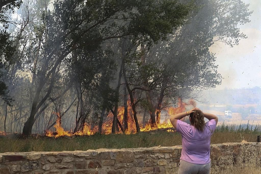 DIJILAT API: Seorang wanita terpaku melihat kebakaran menjilat sebuah kampung di kawasan San Martin de Tabara (Zamora), Sepanyol.