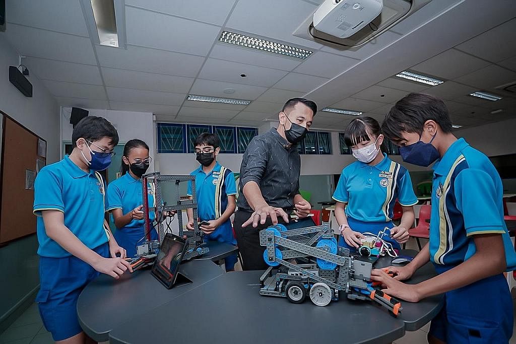 TINGKATKAN KEMAHIRAN: Encik Muhammad Reza Daud (tengah) berkata kemahiran yang dipelajari anak muridnya dalam robotik tidak hanya tertumpu kepada bagaimana mengendalikan robot tetapi juga aspek lain seperti Matematik, semangat berpasukan dan kepimpin
