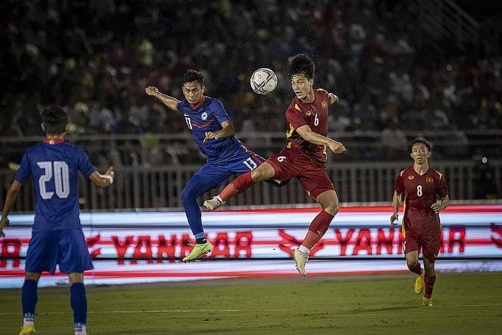TERUS BERIKAN TERBAIK: Adam (jersi biru) melompat untuk cuba menanduk bola daripada pemain Vietnam Luong Duy Cuong dalam perlawanan persahabatan di Ho Chi Minh Rabu lalu. - Foto PERSATUAN BOLA SEPAK SINGAPURA