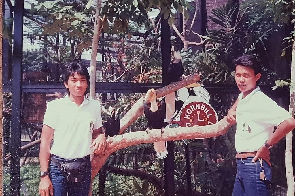DIDIK PENGUNJUNG: Encik Saad (kanan) di sesi 'Hornbill Chit Chat' pertamanya di mana penjaga burung membawa keluar burung enggang dalam sesi perkongsian bersama tetamu. Gambar diambil pada tahun 1990-an. - Foto ihsan MOHAMAD SAAD YAHYA.