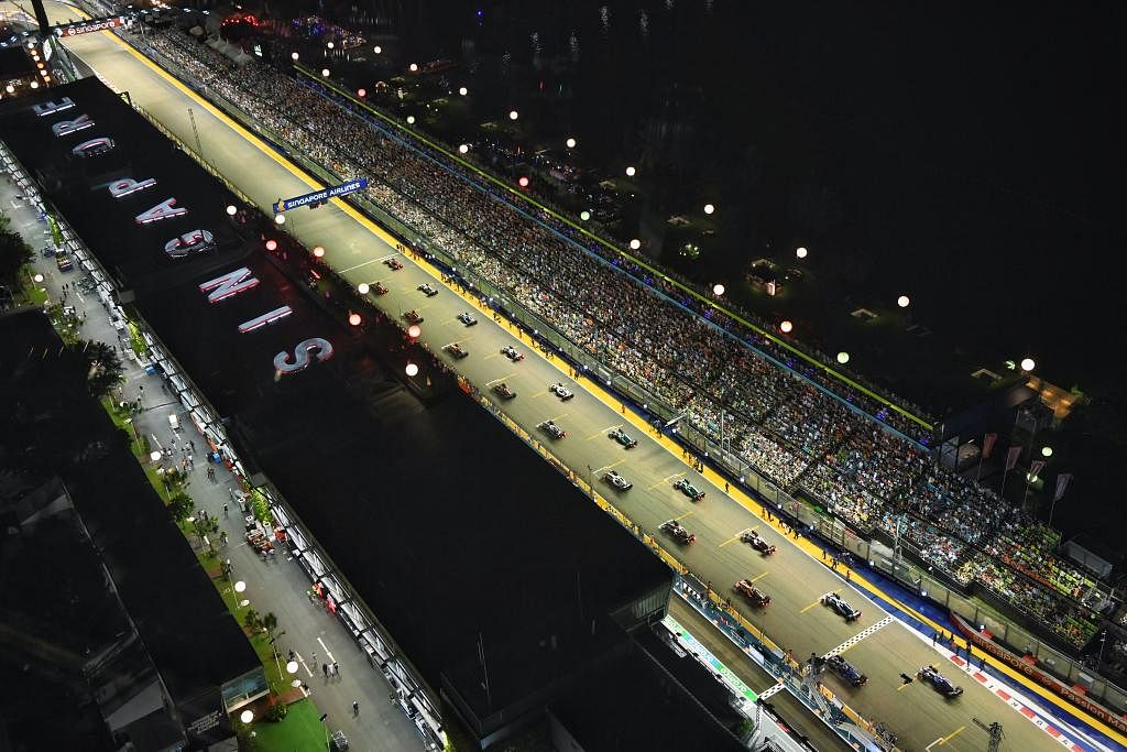 PAPARAN MENARIK: Kereta tersusun mengikut kedudukan grid sejurus sebelum final Grand Prix Singapura bermula pada 2 Oktober. Perlumbaan itu terpaksa ditangguh sekitar sejam kerana hujan. – Foto BH oleh CHONG JUN LIANG