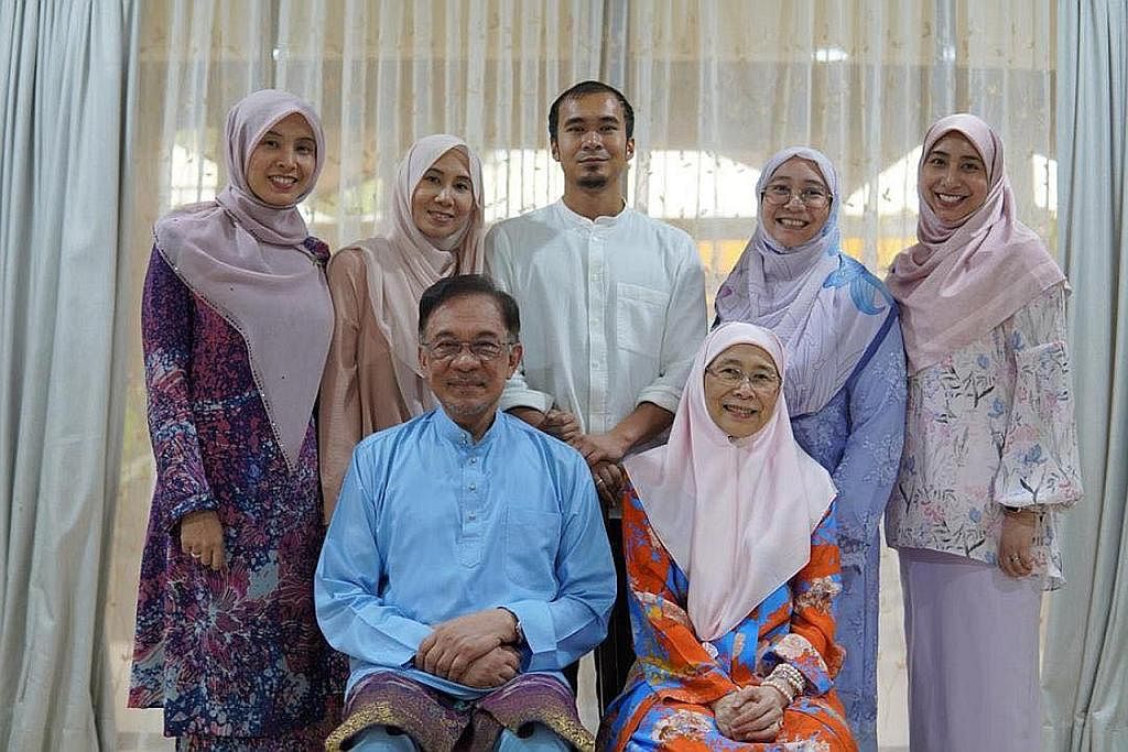 TUMPANG GEMBIRA: Dr Wan Azizah, isteri Datuk Seri Anwar Ibrahim, kelihatan gembira di luar kediaman mereka di Kajang. - Foto REUTERS HARAPAN BARU: Datuk Anwar Ibrahim (depan kiri) bersama isteri Dato' Seri Dr Wan Azizah Wan Ismail. (Belakang dari kir