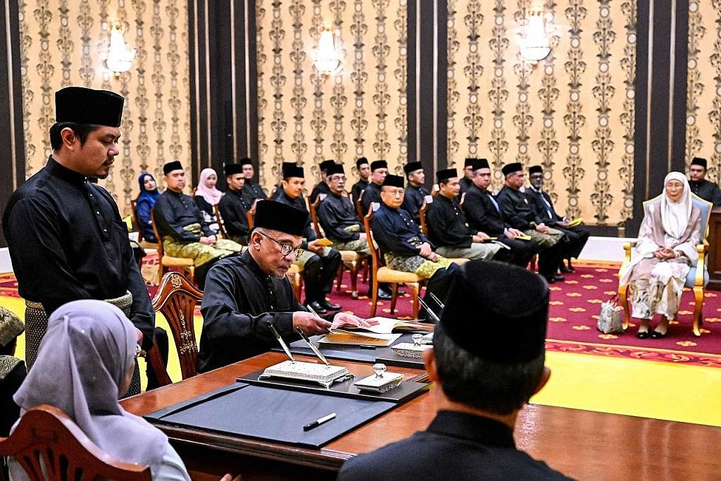 DAPAT SOKONGAN: Penyokong Datuk Seri Anwar Ibrahim menunjukkan sokongan mereka kepada pemimpin itu dengan slogan Anwar Untuk Rakyat Malaysia. - Foto EPA-EFE PERDANA MENTERI BARU: Datuk Seri Anwar (kiri) sempat bergambar bersama (dua dari kiri) Yang d