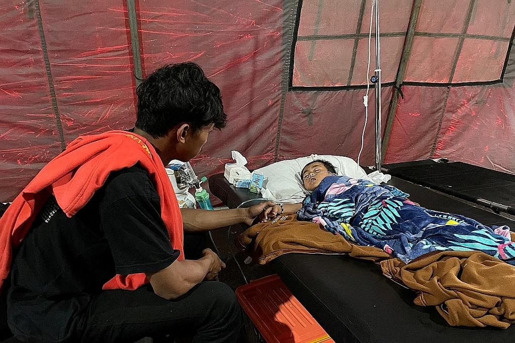 JAGA ADIK: Encik Salman Alfarisi, menemani adiknya, Azka, yang terselamat meskipun berada di bawah timbunan runtuhan selam a dua hari selepas berlaku gempa bumi. - Foto REUTERS