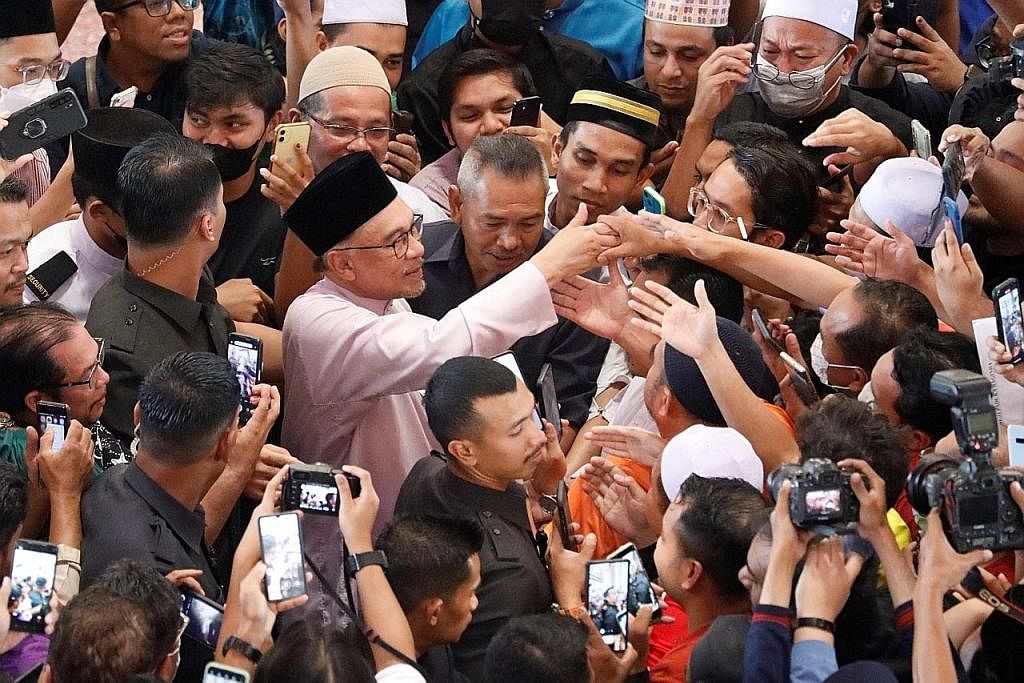 RAKYAT BERSESAKAN: Datuk Seri Anwar Ibrahim bertemu penyokongnya selepas menunaikan sembahyang Jumaat di Masjid Putra, Putrajaya, pada hari pertama beliau memulakan tugas rasmi sebagai Perdana Menteri Malaysia ke-10, kelmarin. - Foto REUTERS DEMI NEG